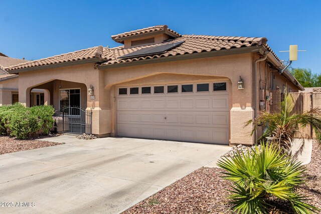 12238 W Monroe St, Avondale, AZ 85323 - mediterranean / spanish home featuring a garage, concrete driveway, stucco siding, and solar panels