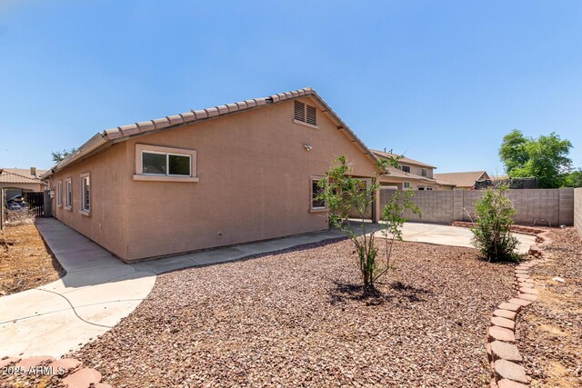 12238 W Monroe St, Avondale, AZ 85323 - view of side of home with fence, a patio area, and stucco siding