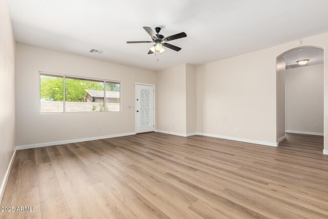 12238 W Monroe St, Avondale, AZ 85323 - spare room with arched walkways, light wood-style floors, ceiling fan, and baseboards