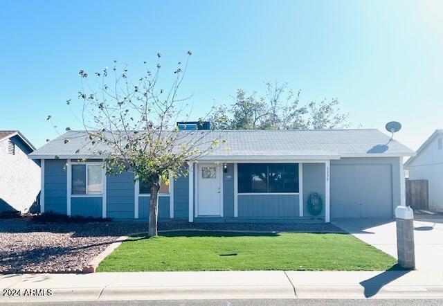 ranch-style house featuring a garage and a front lawn