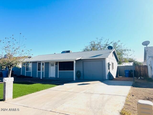 ranch-style house featuring a front lawn and a garage