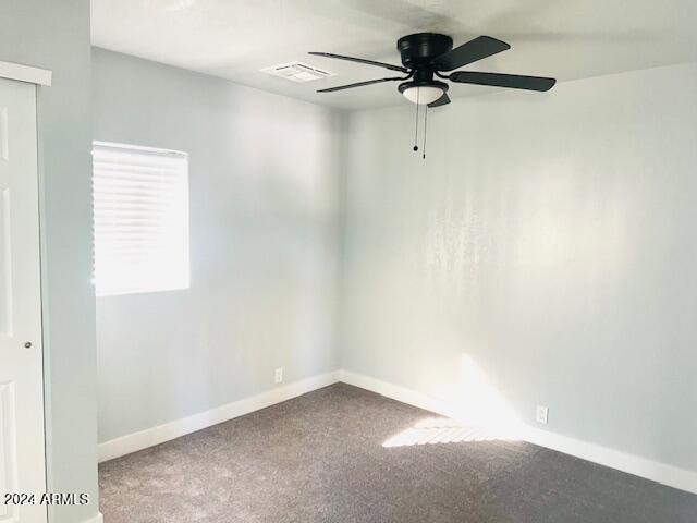 carpeted spare room featuring ceiling fan