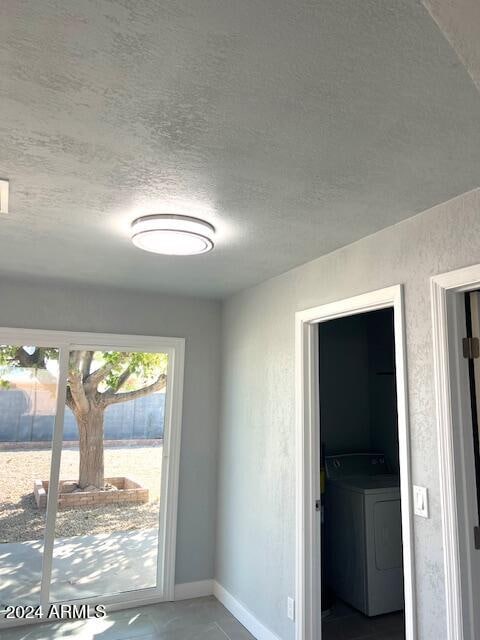 entryway with washer / clothes dryer and a textured ceiling