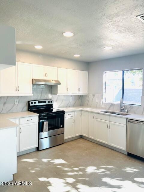 kitchen with tasteful backsplash, white cabinetry, appliances with stainless steel finishes, a textured ceiling, and sink