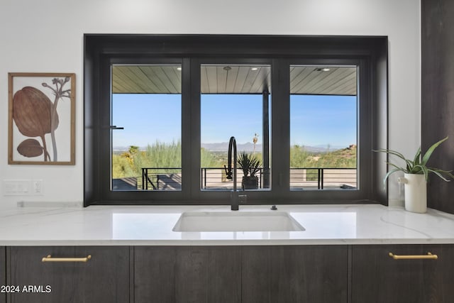 kitchen with light stone counters, sink, and a wealth of natural light