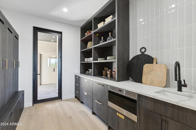 interior space with light stone counters, sink, and light hardwood / wood-style floors