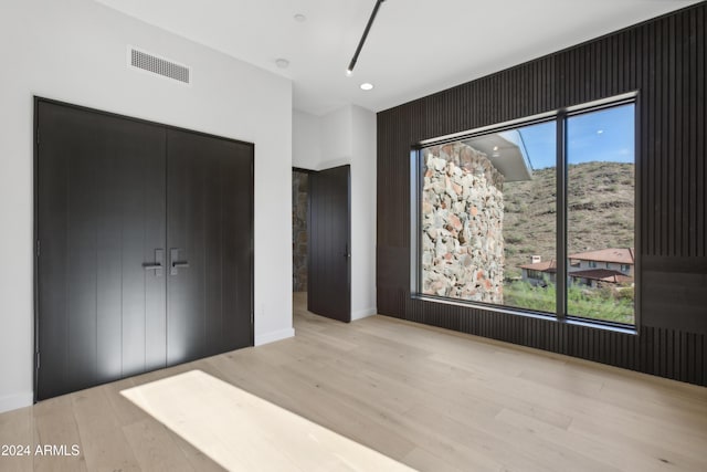 unfurnished bedroom with a closet and light wood-type flooring