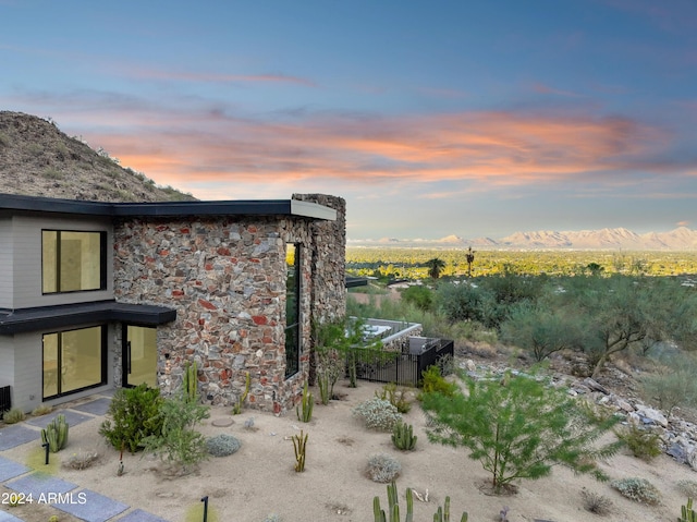 property exterior at dusk featuring a mountain view