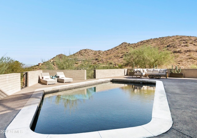 view of pool with an outdoor living space, a mountain view, and a patio