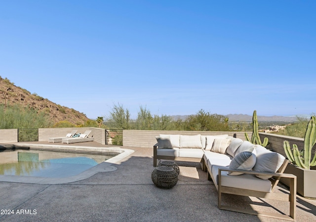 view of swimming pool with a patio area, an outdoor living space, and a mountain view