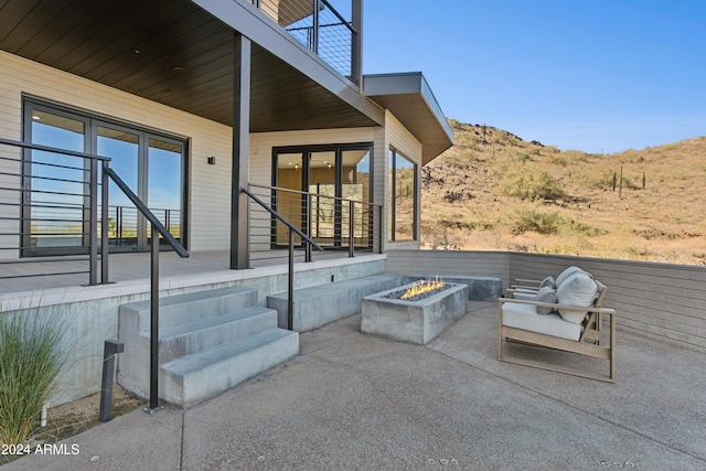 view of patio / terrace with a mountain view and an outdoor fire pit