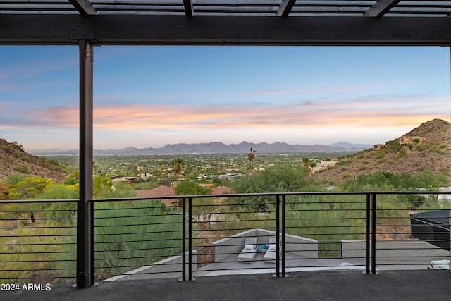 balcony at dusk featuring a mountain view