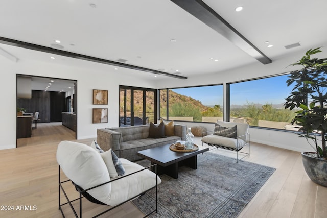 living room with light wood-type flooring and beam ceiling