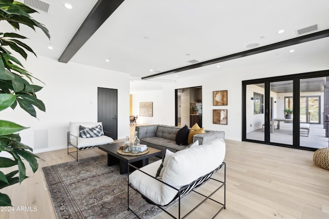 living room featuring light hardwood / wood-style floors, beam ceiling, and french doors