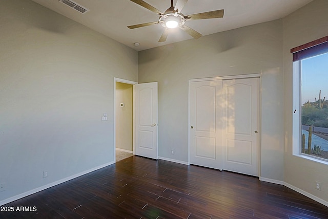 5520 E Desert Forest Trl, Cave Creek, AZ 85331 - unfurnished bedroom with dark wood-type flooring, baseboards, a closet, and a ceiling fan