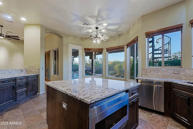 5520 E Desert Forest Trl, Cave Creek, AZ 85331 - kitchen with stainless steel appliances, ceiling fan, tasteful backsplash, arched walkways, and recessed lighting