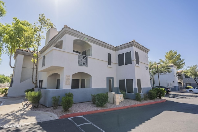 600 W Grove Pkwy Unit 2188, Tempe, AZ 85283 - view of front of home featuring stucco siding, a balcony, a chimney, and a tile roof