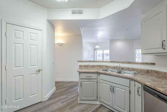 600 W Grove Pkwy Unit 2188, Tempe, AZ 85283 - kitchen with stainless steel dishwasher, a peninsula, light wood-style floors, light countertops, and white cabinets