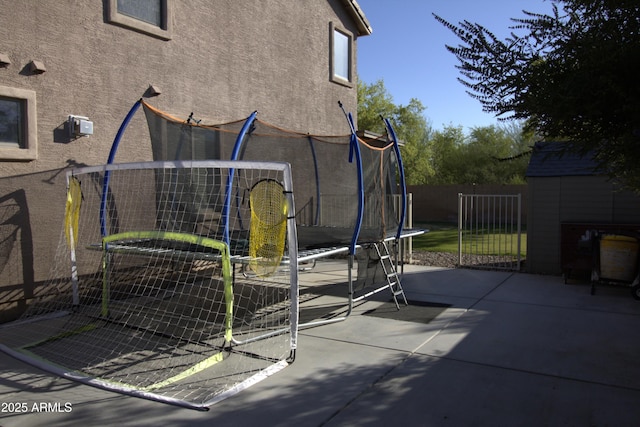 8920 S 40th Ln, Laveen, AZ 85339 - view of side of property with a trampoline, stucco siding, and a patio area
