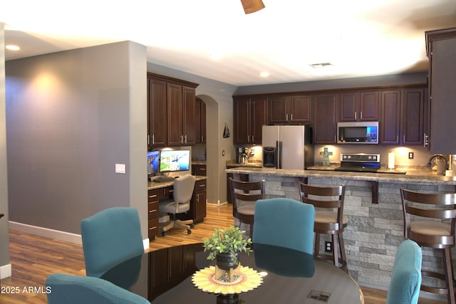 8920 S 40th Ln, Laveen, AZ 85339 - kitchen with stainless steel microwave, white refrigerator with ice dispenser, electric stove, arched walkways, and dark brown cabinets