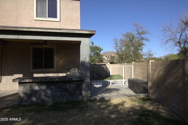 8920 S 40th Ln, Laveen, AZ 85339 - view of side of property featuring a fenced backyard, stucco siding, a patio area, and ceiling fan