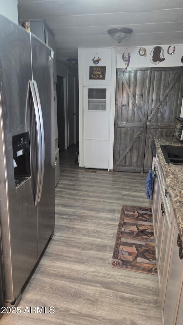 8920 S 40th Ln, Laveen, AZ 85339 - kitchen featuring stainless steel fridge with ice dispenser, wood finished floors, a sink, and stone countertops