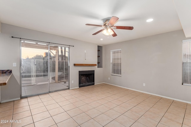 unfurnished living room featuring ceiling fan and light tile patterned floors