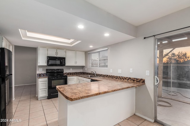 kitchen with kitchen peninsula, sink, black appliances, light tile patterned flooring, and white cabinets