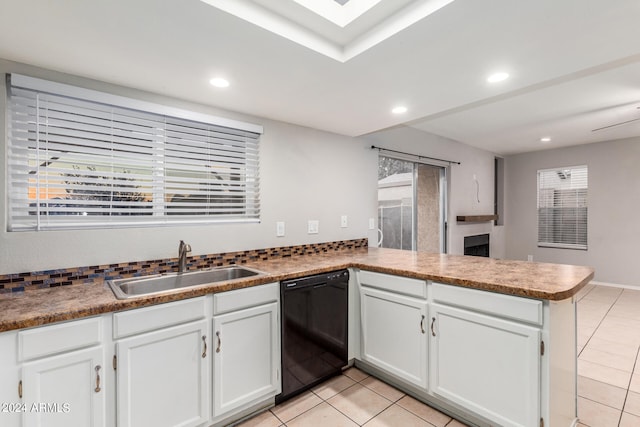 kitchen featuring kitchen peninsula, black dishwasher, light tile patterned floors, white cabinetry, and sink