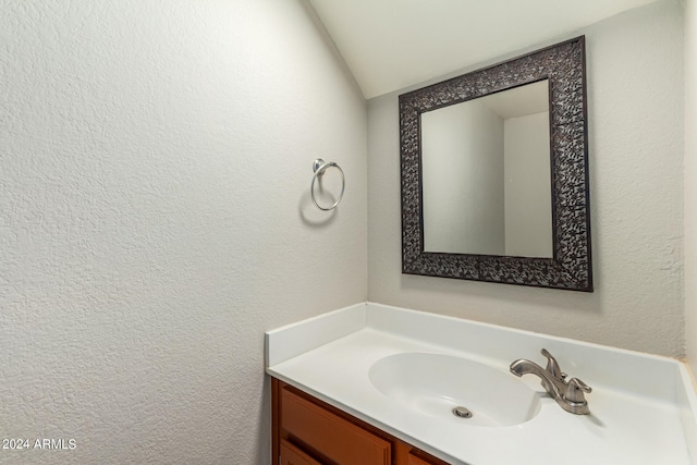 bathroom with vanity and lofted ceiling