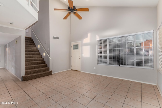 tiled entryway with ceiling fan and high vaulted ceiling