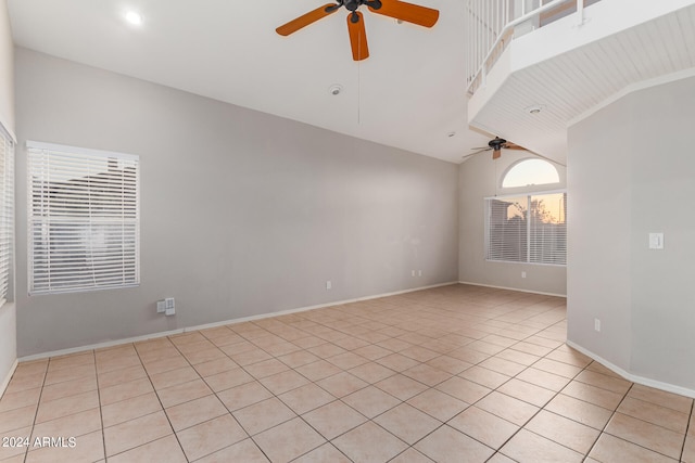 tiled spare room featuring ceiling fan and high vaulted ceiling