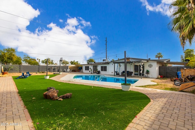 view of pool with a patio area and a lawn