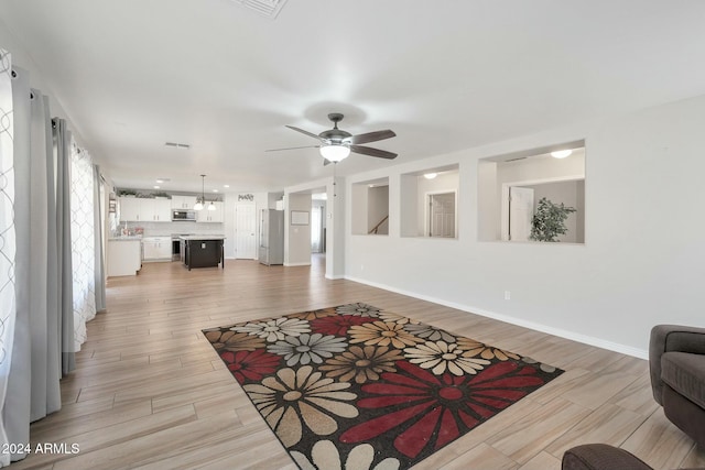 living room with light hardwood / wood-style flooring and ceiling fan