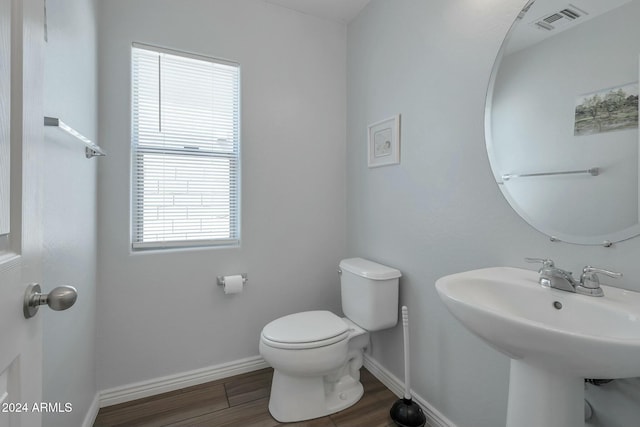 962 W Lindbergh Ave, Coolidge, AZ 85128 - bathroom featuring toilet, sink, plenty of natural light, and hardwood / wood-style flooring