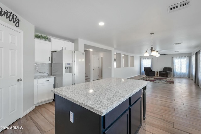 962 W Lindbergh Ave, Coolidge, AZ 85128 - kitchen with white cabinetry, white fridge with ice dispenser, a kitchen island, and light hardwood / wood-style flooring