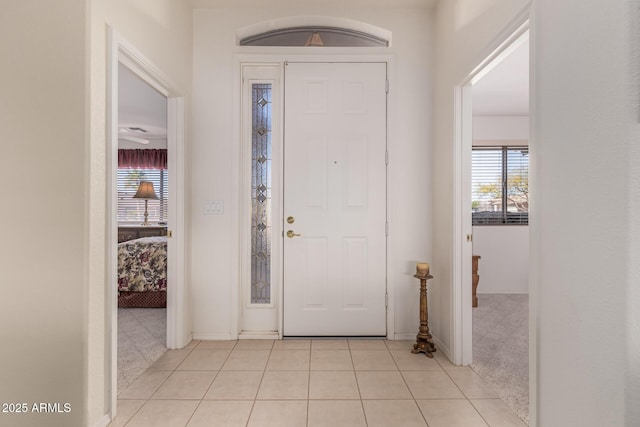 foyer with light tile patterned floors and a wealth of natural light