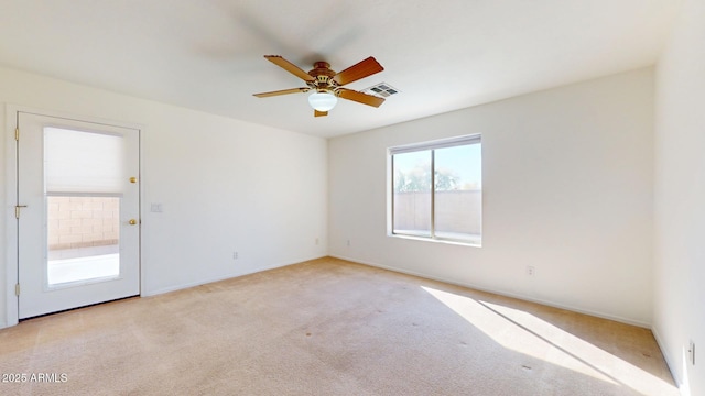 spare room with visible vents, light colored carpet, and a ceiling fan