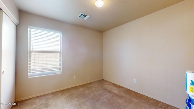 unfurnished room featuring light carpet, visible vents, and baseboards