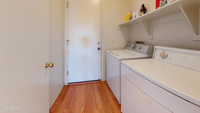 laundry room with independent washer and dryer, light wood-style flooring, and laundry area