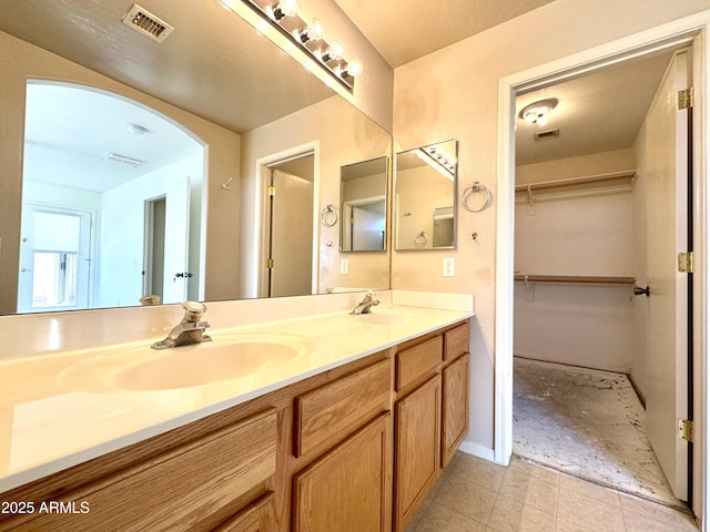 full bath featuring double vanity, visible vents, and a sink