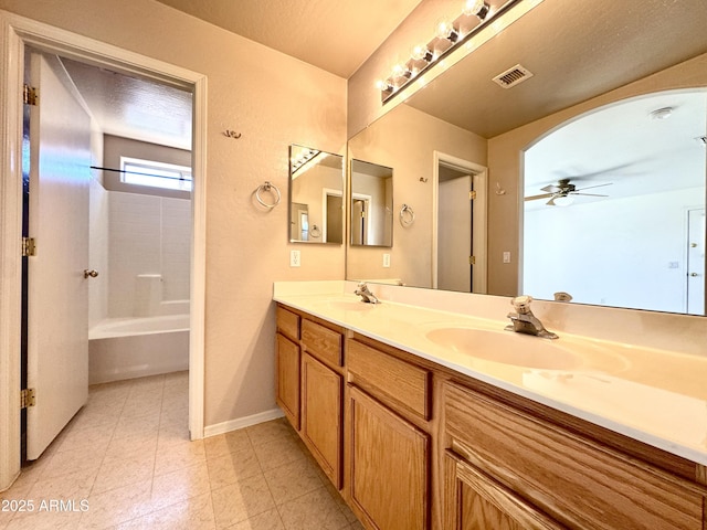 bathroom with a sink, visible vents, double vanity, and a ceiling fan