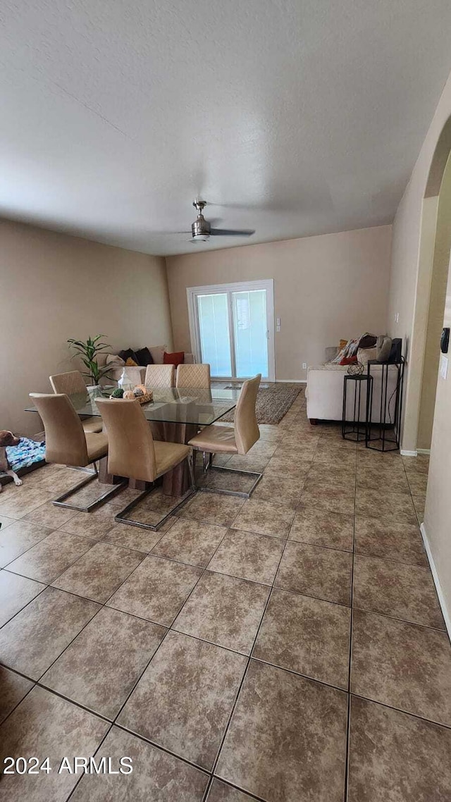 tiled dining room featuring a textured ceiling and ceiling fan