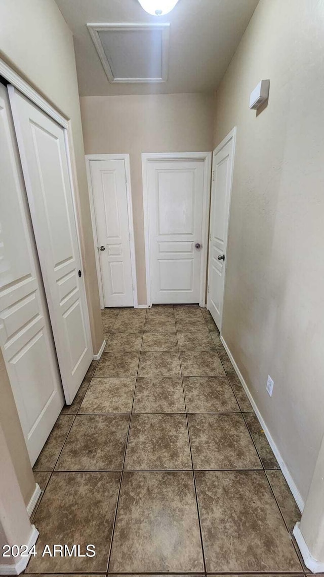 corridor featuring dark tile patterned floors