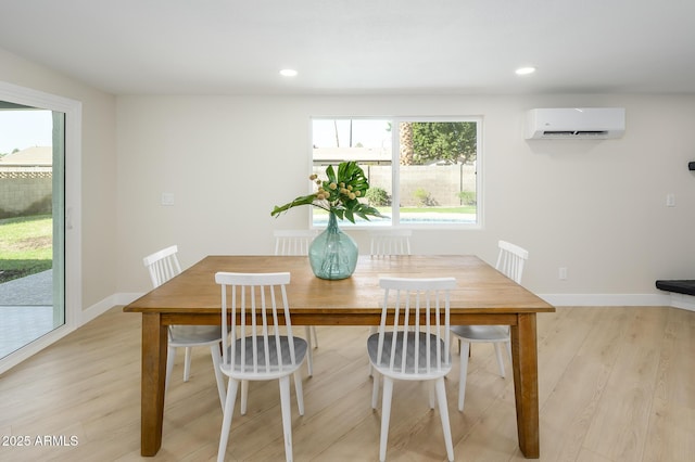 unfurnished dining area featuring a wall mounted AC and light hardwood / wood-style flooring