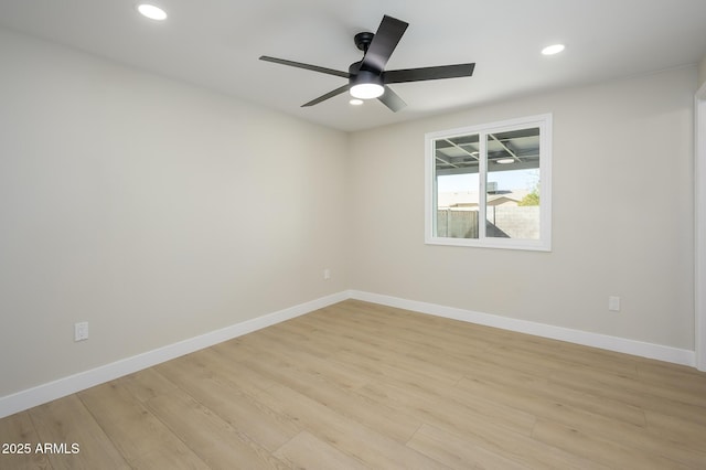 spare room with ceiling fan and light wood-type flooring