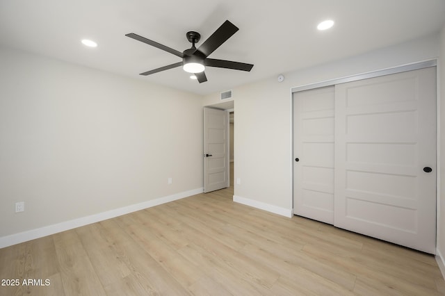 unfurnished bedroom with ceiling fan, a closet, and light wood-type flooring