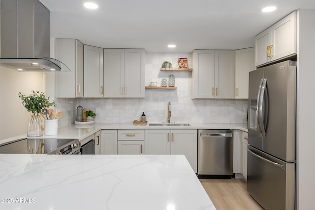 kitchen featuring ventilation hood, sink, light hardwood / wood-style floors, light stone counters, and stainless steel appliances