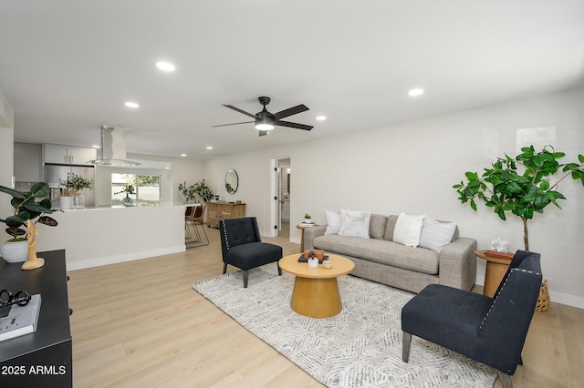 living room with ceiling fan and light hardwood / wood-style floors