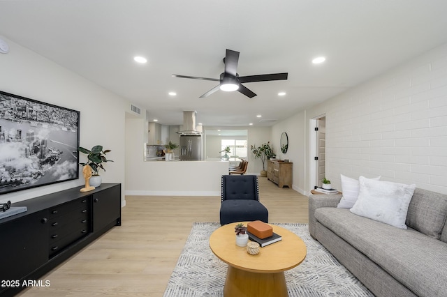 living room with ceiling fan and light hardwood / wood-style floors